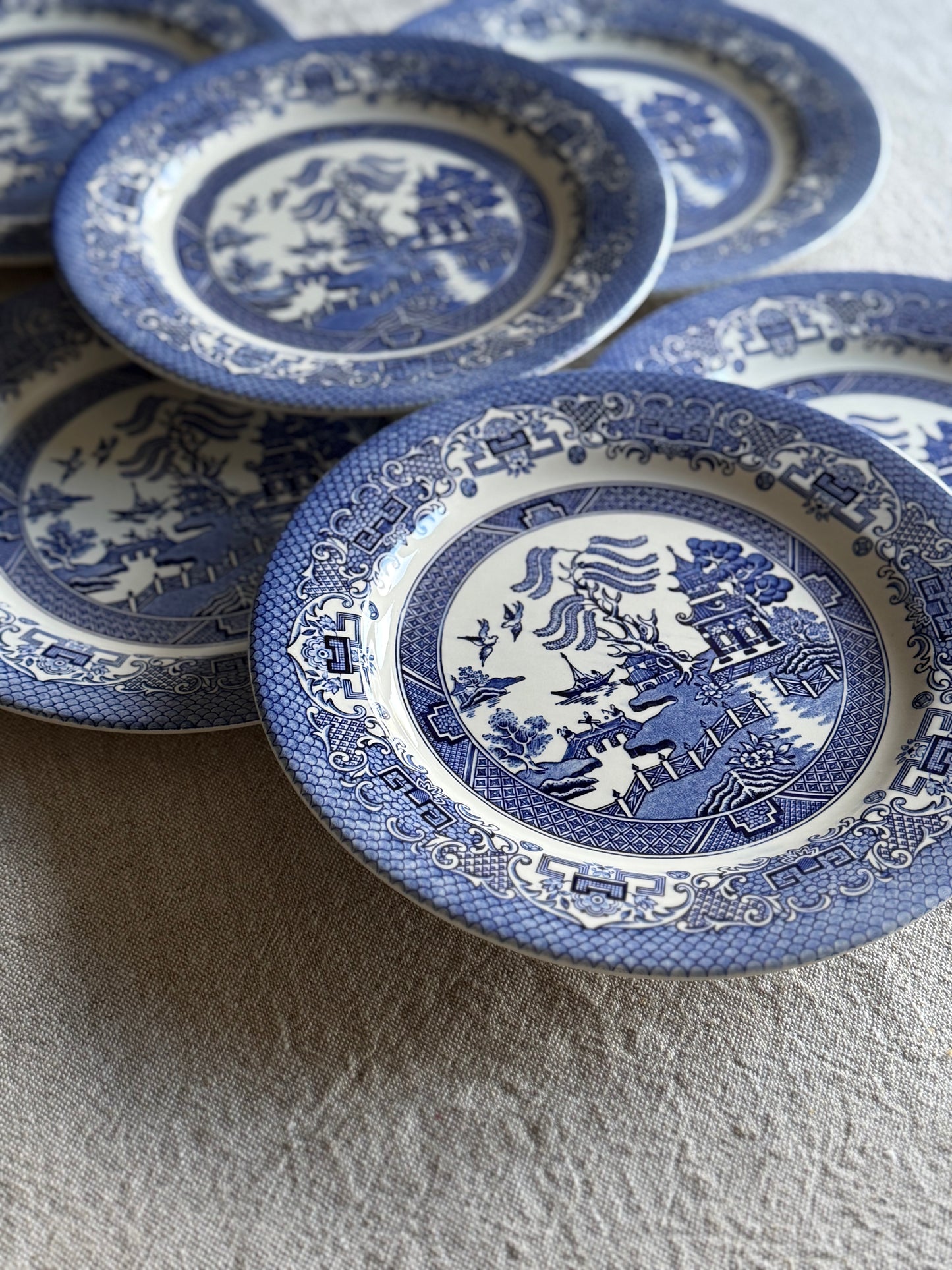 Set of six vintage dinner Blue Willow pattern plates in classic blue and white.