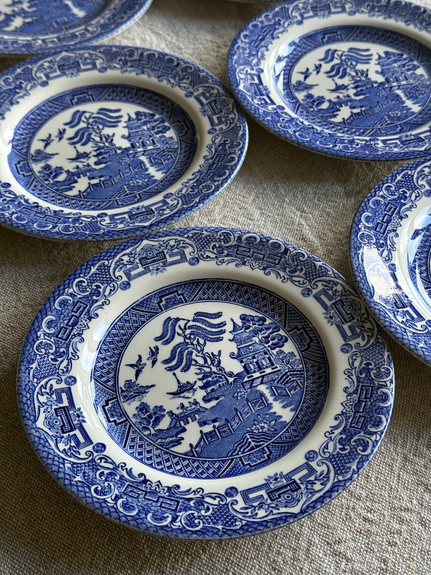Set of six vintage Blue Willow pattern side plates in classic blue and white.