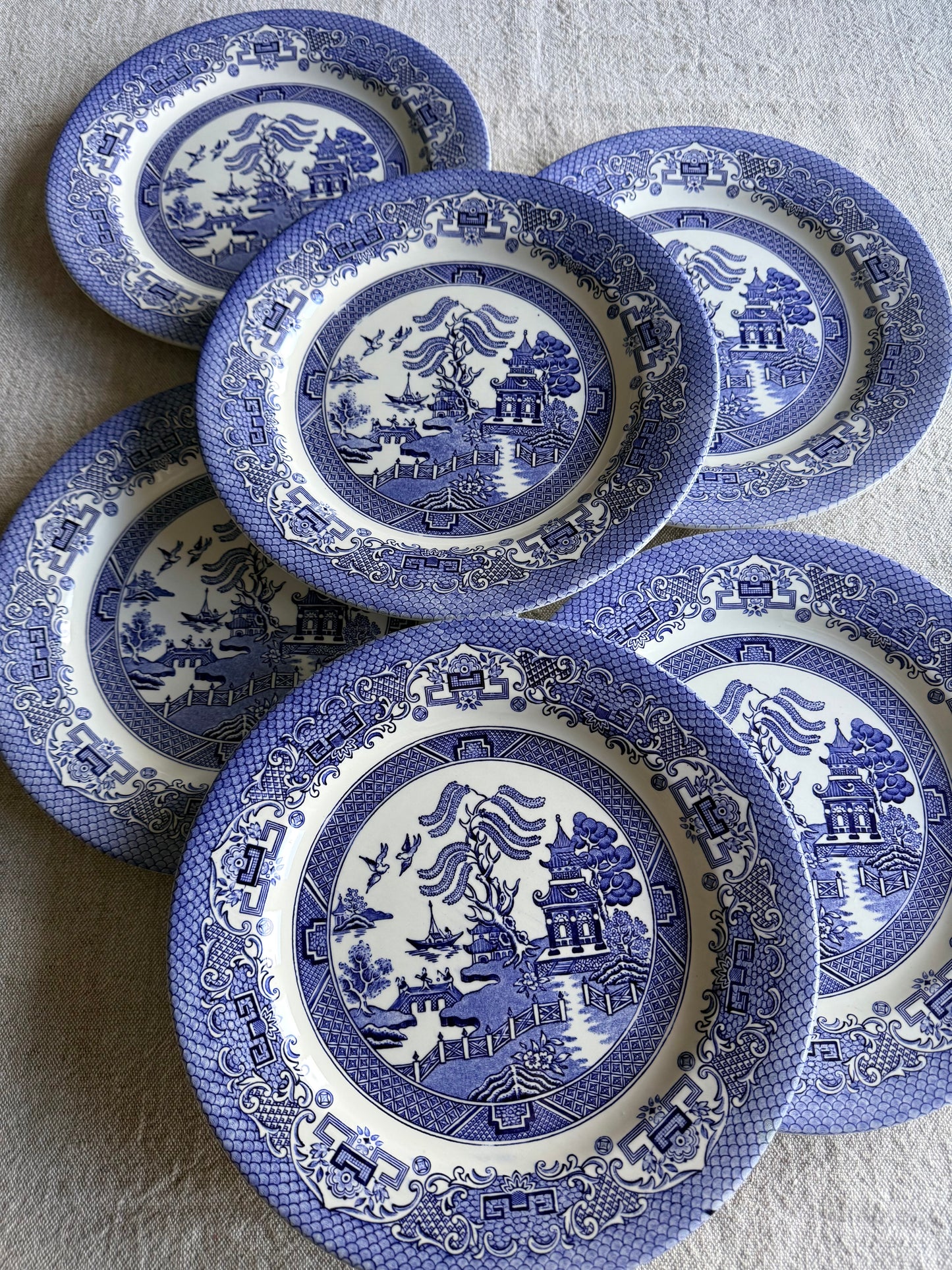 Set of six vintage dinner Blue Willow pattern plates in classic blue and white.